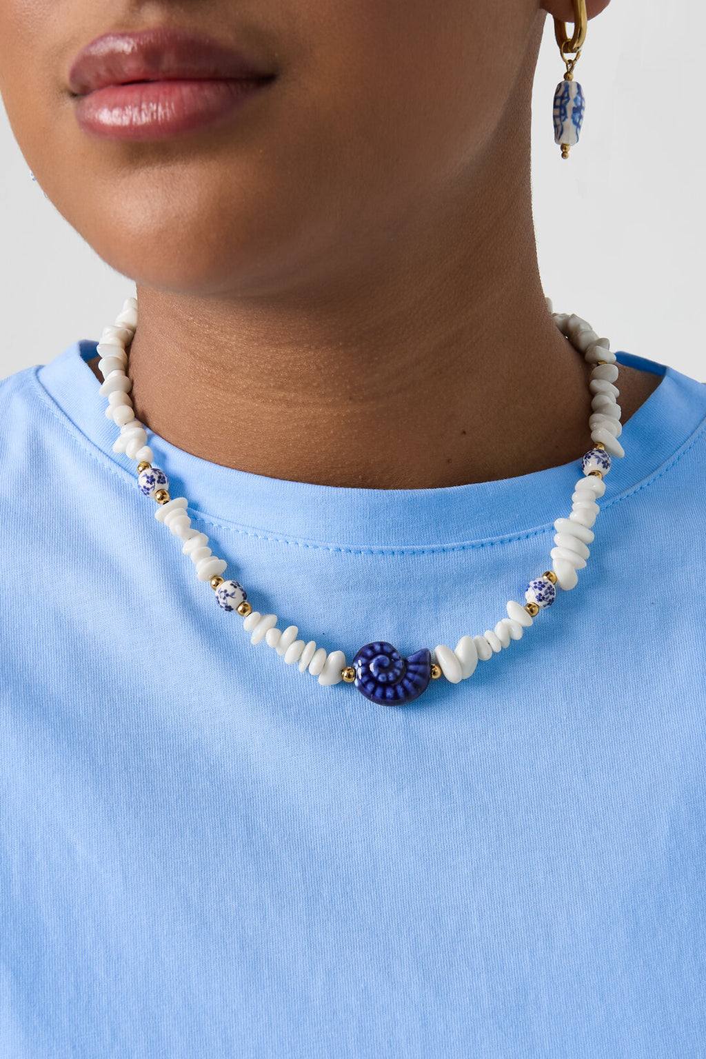 Necklace with stone beads, white beads with blue flowers and statement shell