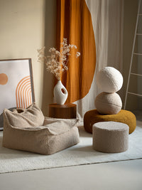 Wigiwama teddy sierkussen in beige kleur als decoratief accent op een bijpassende poef en zitzak. Veilig, zacht en stijlvol in ieder interieur.
