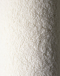 Close-up van de heerlijk zachte OEKO-TEX® gecertificeerde teddystof van het Wigiwama beerkussen in de kleur cream. Perfect voor een knusse, veilige kinderkamer.