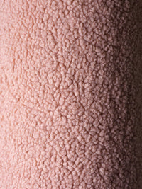 Close-up van de OEKO-TEX® gecertificeerde teddystof in guava pink kleur. Laat de zachte, pluizige structuur zien van het roze Wigiwama sierkussen in balvorm.