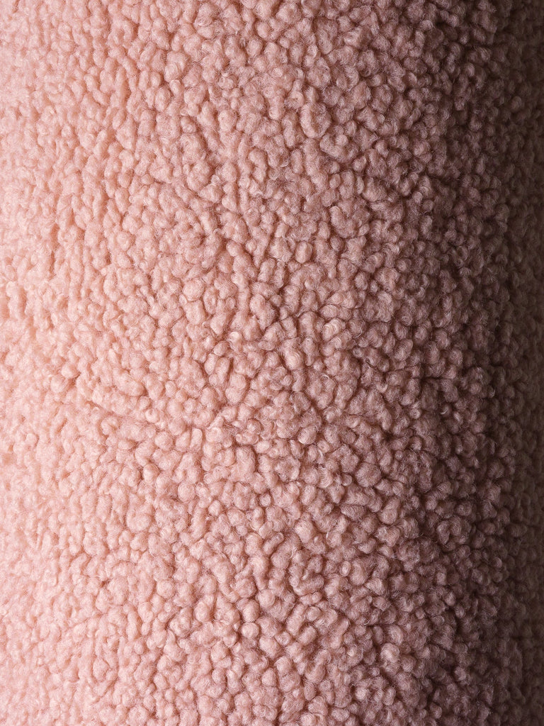 Close-up van de OEKO-TEX® gecertificeerde teddystof in guava pink kleur. Laat de zachte, pluizige structuur zien van het roze Wigiwama sierkussen in balvorm.