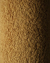 Close-up van de OEKO-TEX® gecertificeerde teddystof in maple kleur van het okergele Wigiwama sierkussen. Laat de zachte en veilige structuur van de stof zien.