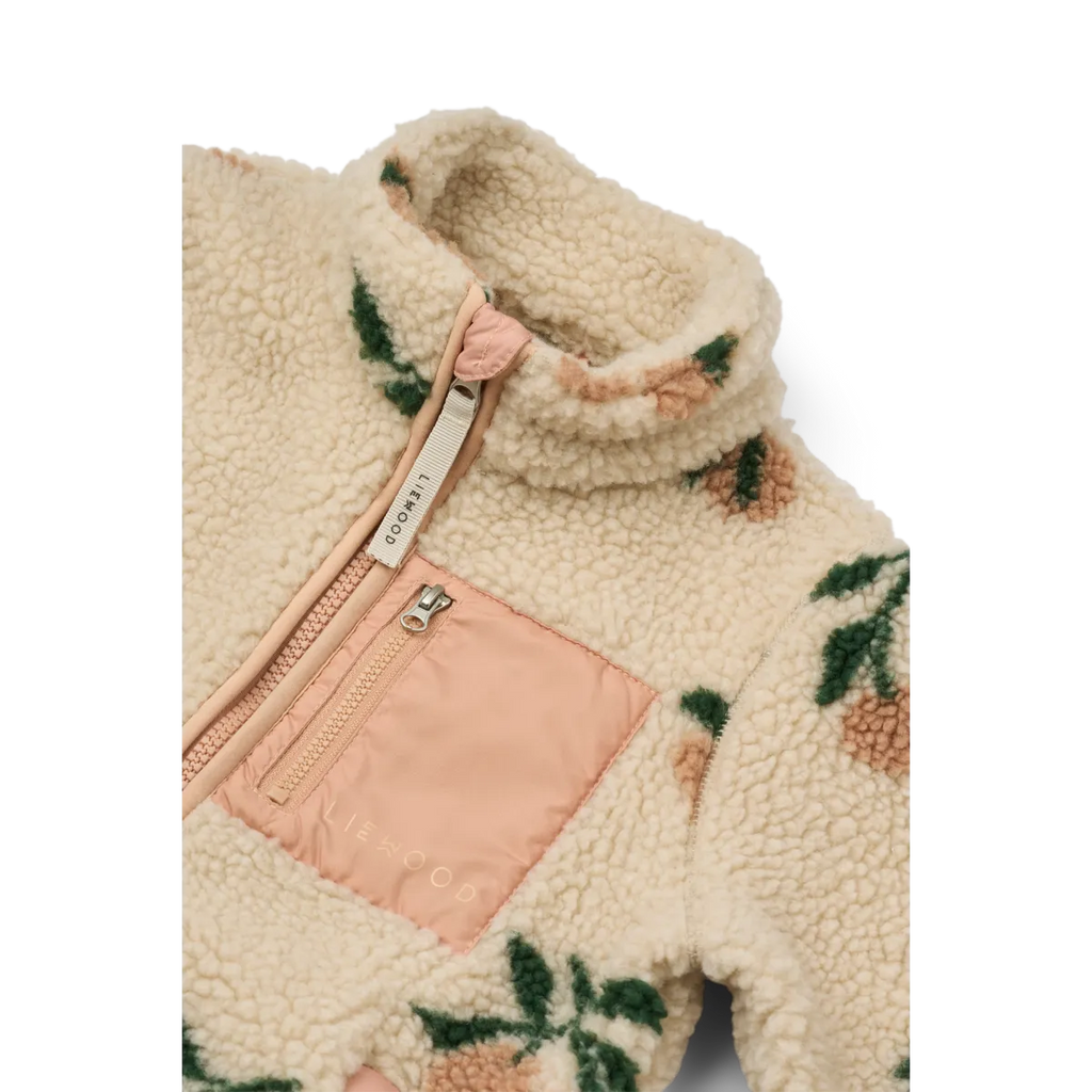 Creme jasje, detailfoto van de hals, de perzik kleur details en de teddy stof