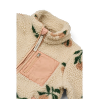 Creme jasje, detailfoto van de hals, de perzik kleur details en de teddy stof