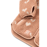 Detailfoto van het zachtroze Liewood jasje met hartjes, waarbij de rondlopende onderrand, de mouwen met inkeping en de katoenen binnenzijde goed getoond wordt