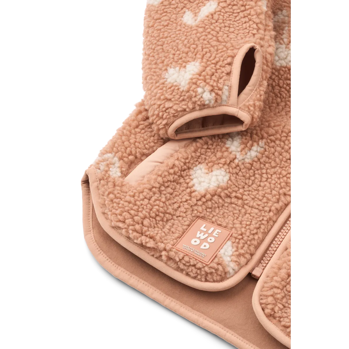 Detailfoto van het zachtroze Liewood jasje met hartjes, waarbij de rondlopende onderrand, de mouwen met inkeping en de katoenen binnenzijde goed getoond wordt