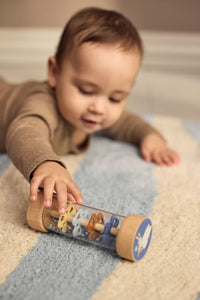 Baby ontdekt de houten rainmaker uit de sensorische speelset van Filibabba. De rainmaker heeft bewegende kralen en het zachte, rustgevende geluid van regen.