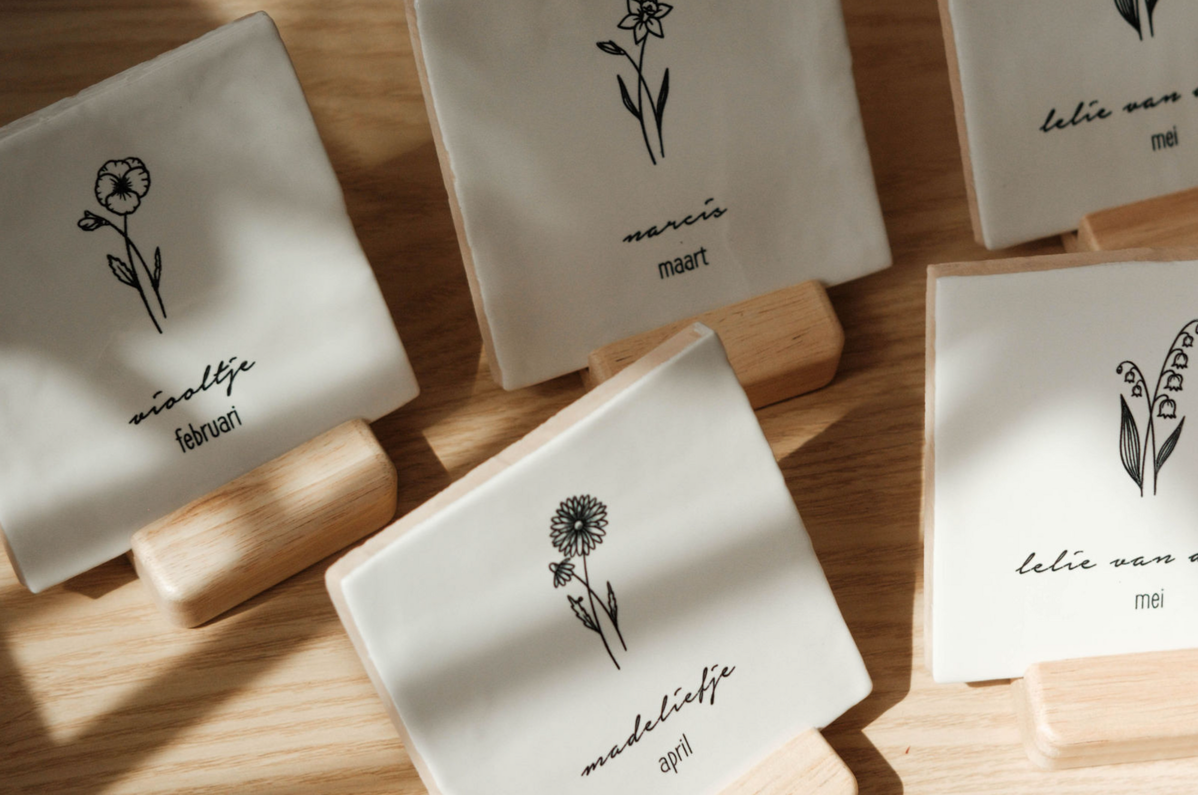 Bij Boetiek Blij graveren wij onze tegeltjes zelf. Standaard hebben wij geboortebloemen en sterrenbeelden in onze collectie, maar ook jouw eigen ontwerp maken we graag voor je. Tegeltjes beschikbaar in wit, poederroze, mintgroen of zandkleur. En natuurlijk maak je het kadootje compleet met een beukenhouten standaardje.