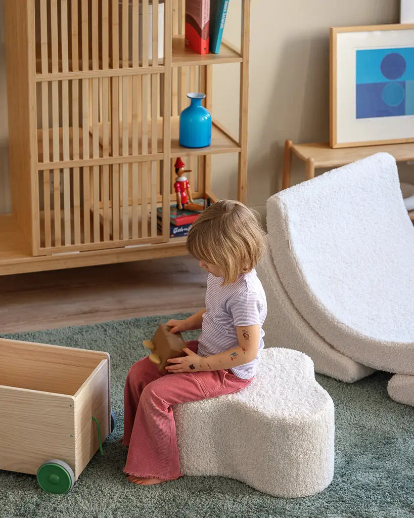 Kindje wat zit op de organisch gevormde Cloud poef van Wigiwama. De vorm doet ook echt denken aan een wolk. Perfect om te combineren met andere kindermeubels van Wigiwama