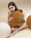 Kind met zachte teddy kussens van Wigiwama, waaronder de bal in cream kleur. Comfortabel, veilig en uitnodigend voor rust of spel.