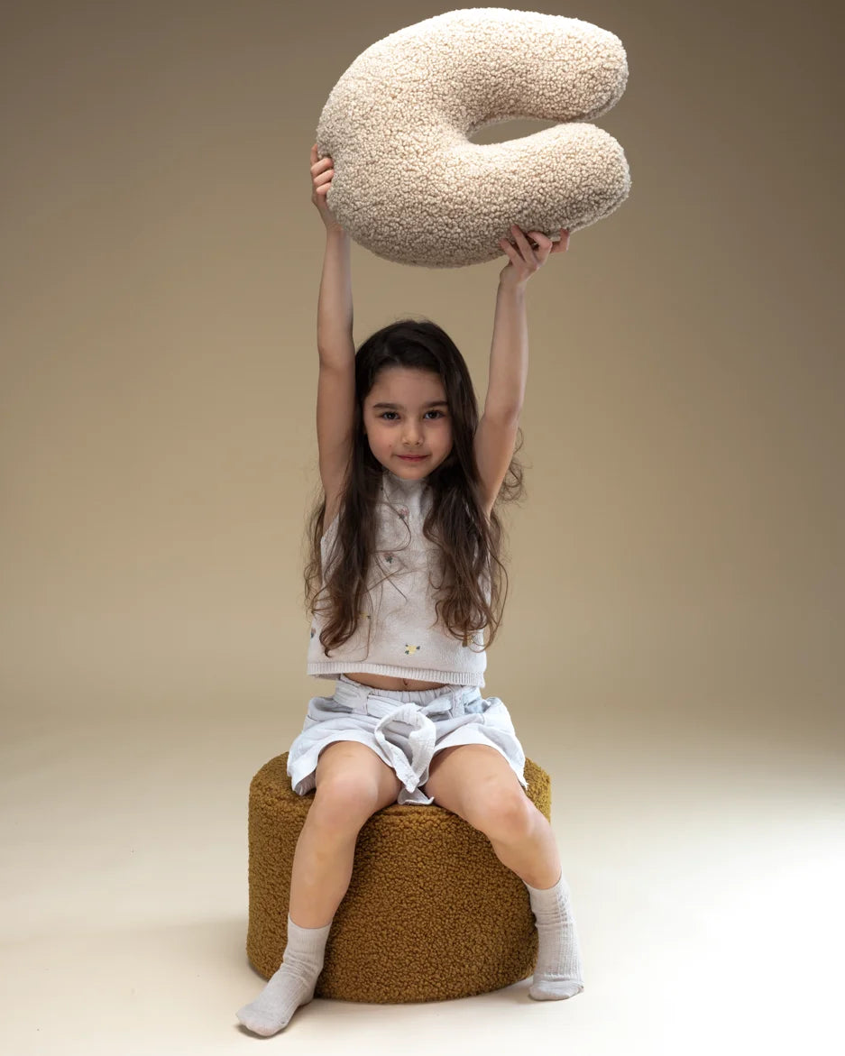 Een vrolijk meisje tilt het teddy sierkussen op in de lucht – het ideale accessoire voor knuffelmomenten, spelen of ontspannen lezen. De zachte stof en vriendelijke vorm zorgen voor comfort en veiligheid.