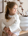 Kind knuffelt het creamkleurige (offwhite) teddy sterkussen van Wigiwama – gemaakt van veilige, OEKO-TEX® gecertificeerde stof.