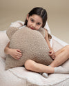 Knusse sfeer met een meisje dat het teddy beren kussen omarmt. De zachte, OEKO-TEX® gecertificeerde stof en stevige vulling maken dit kussen een favoriet rustplekje in elke kinderkamer of speelhoek.