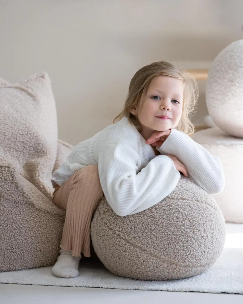 Meisje wat zit op de biscuit teddy zitzak stoel van Wigiwama, ze leunt op een grote teddy bal uit dezelfde serie