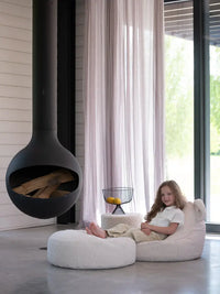 Meisje zit heerlijk te chillen op een Wigiwama zitzak, haar voeten heerlijk languit op de bijpassende ronde poef