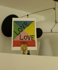 Voorbeeld van de messing kaarthouder van Doing Goods met een 'love' kaart daarin