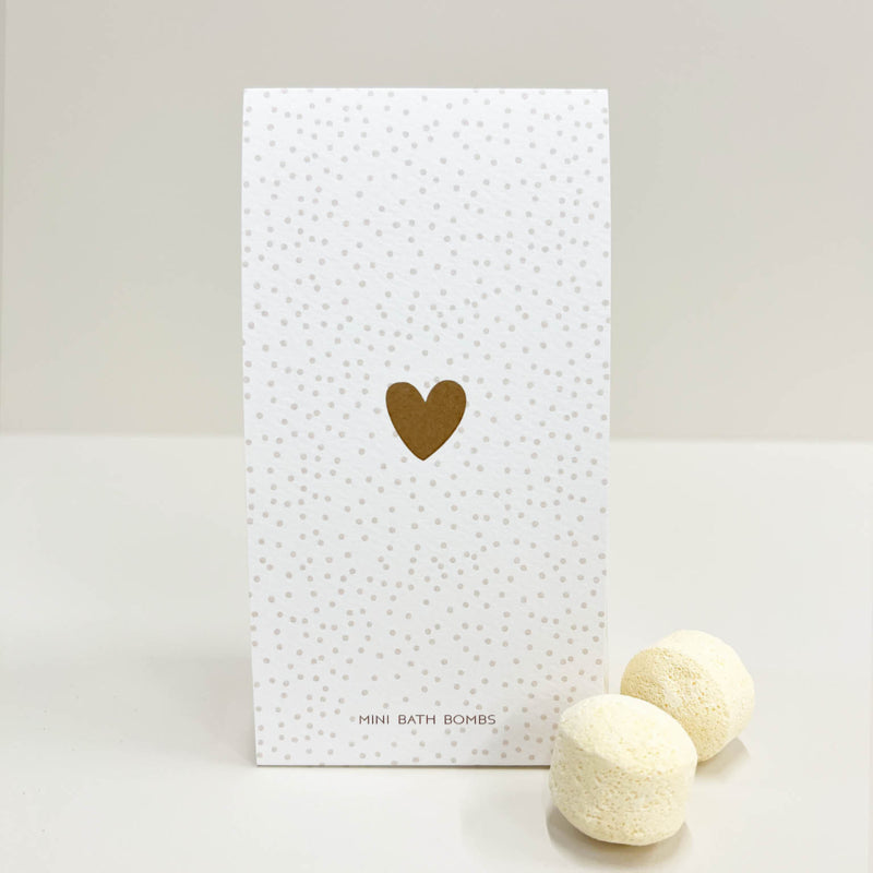 Een kartonnen doosje met gouden spikkels en een gouden hartje, met daarin kleine badbruisballen voor in bad of een voetenbadje. Voor jezelf of als kado.