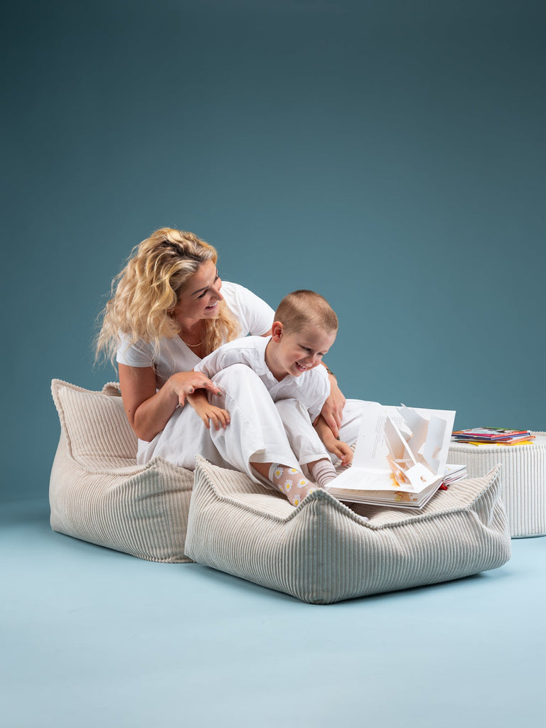 Moeder en jongetje die zitten en spelen op een zitzak / stoel en poef van Wigiwama, de kleur van deze combinatie is marshmallow