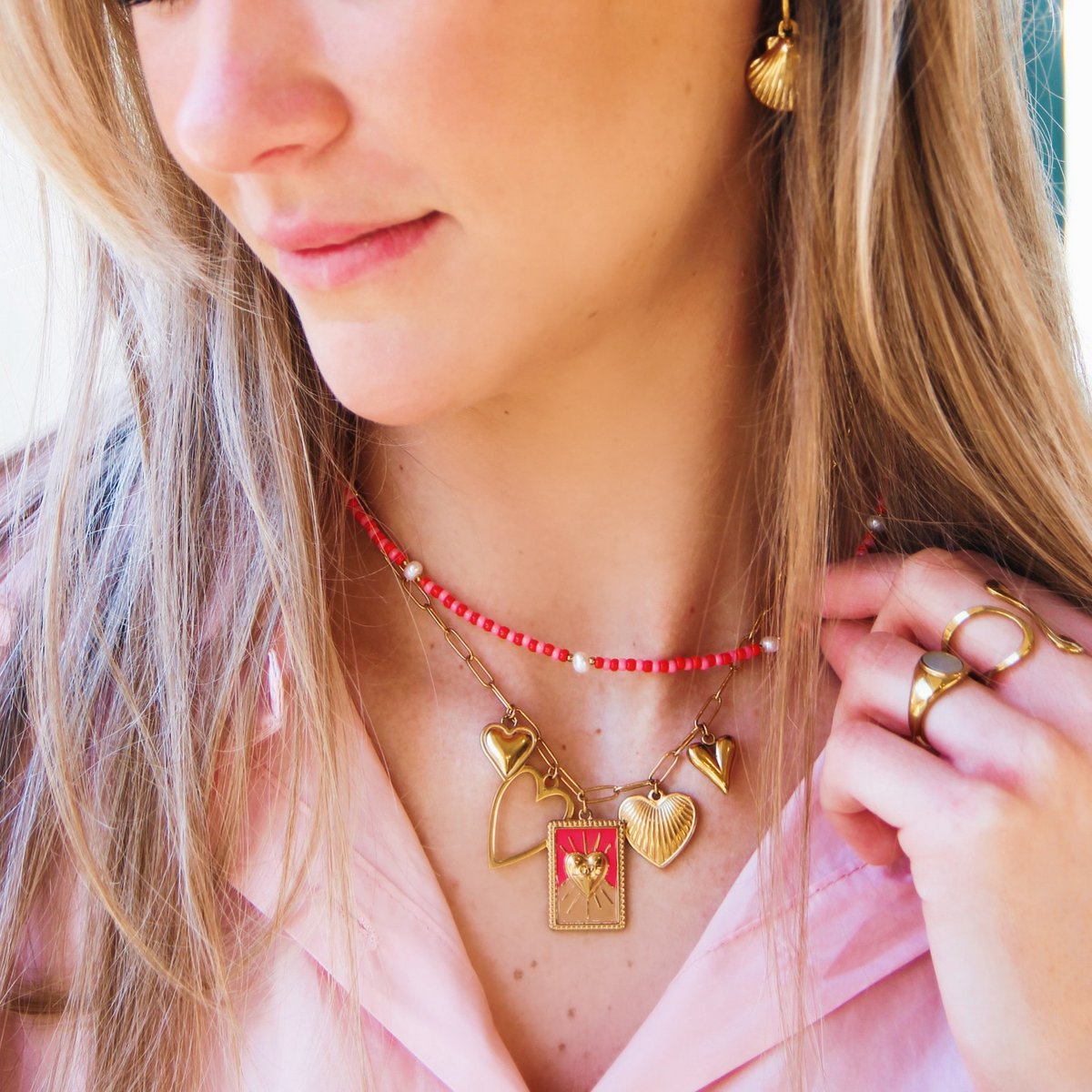 Oorbellen in de vorm van schelpjes, goudkleur. Op de foto gecombineerd met een bedelketting in rood en goud.