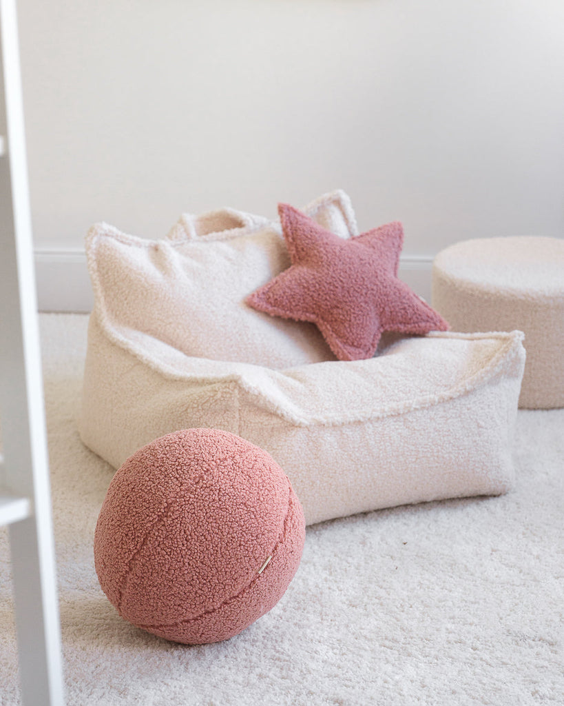 Offwhite stoel / zitzak voor kinderen, met een roze teddy sierkussen in de vorm van een ster en één in de vorm van een bal.