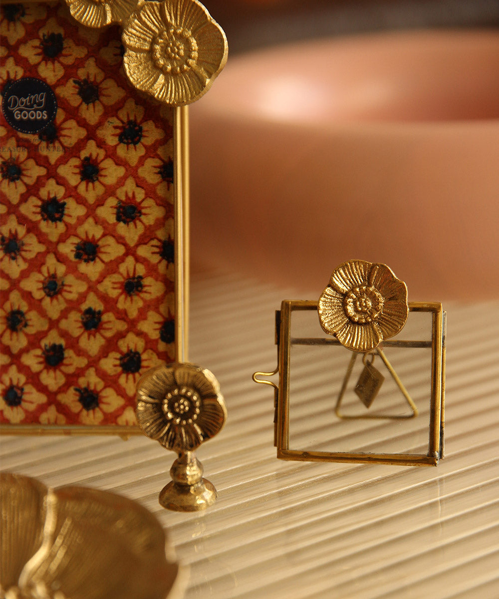 Sfeerbeeld van de messing Mia Poppy kaarthouder van Doing Goods, gecombineerd met fotolijstjes uit diezelfde serie 