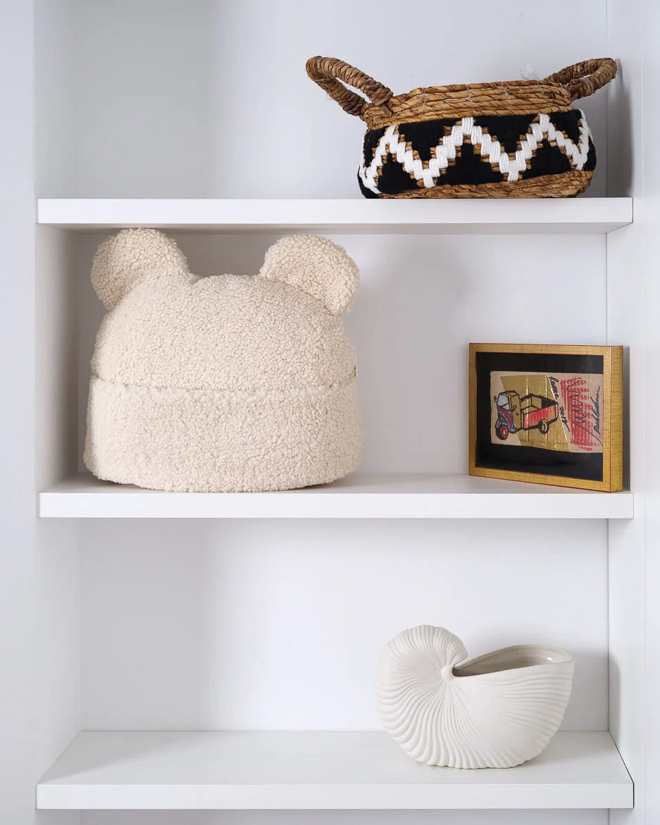 Het creamkleurige teddy beerkussen van Wigiwama vormt een speelse én stijlvolle toevoeging aan de kinderkamer – een rustgevend accessoire met zachte oortjes en opbergvakje.