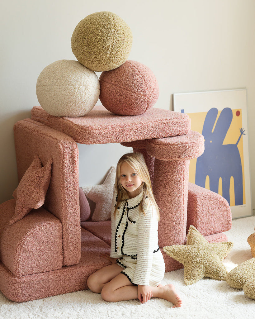 Gezellige speelhoek met Wigiwama sierkussens in verschillende kleuren, waaronder het zachte groene teddy kussen in matcha. Ideaal voor fantasierijk spelen en relaxen.