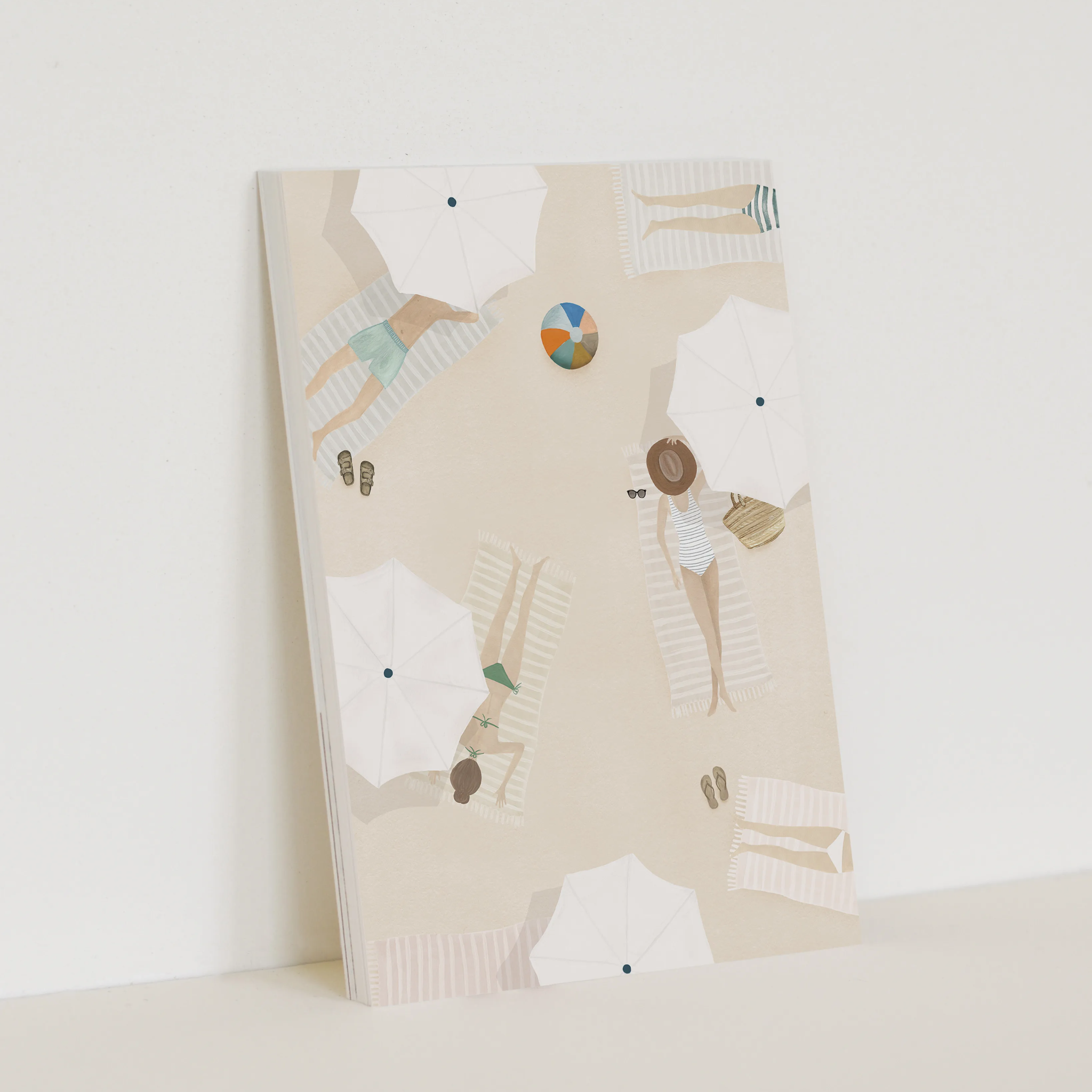 Enkele kaart van Sâlt + Flor, een kleine Nederlandse ontwerper. Illustratie van personen liggend op het strand, met witte parasols