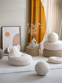 Ronde poefen of poefs, een bijzettafeltje, een zitzak met beer oortjes en 3 grote ballen om mee te spelen. Allemaal in dezelfde teddy serie van Wigiwama, verkrijgbaar in verschillende kleuren. Op de foto offwhite en beige producten.