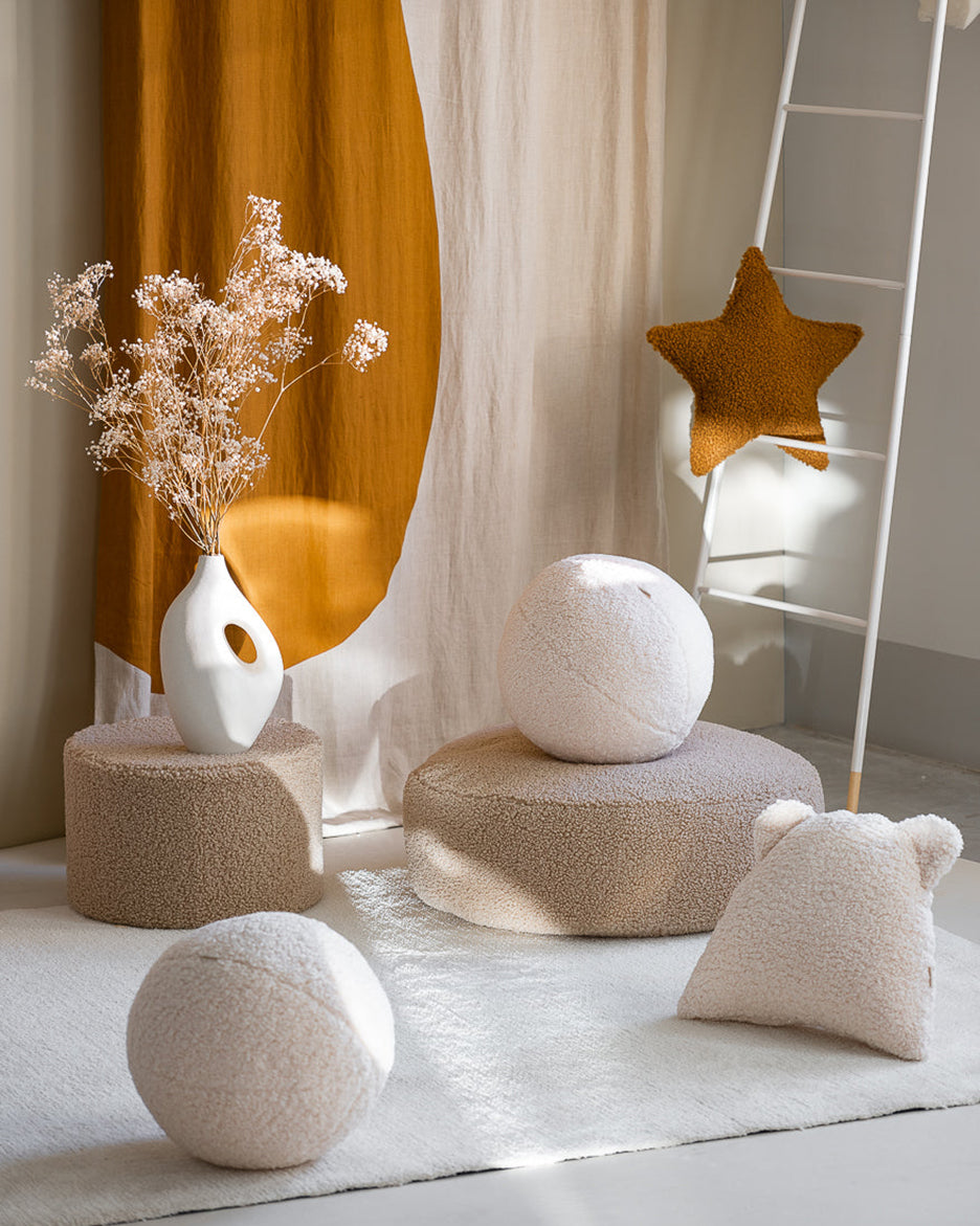 Een rustgevend interieur met zachte Wigiwama poefs, speelballen en het kussen met berenoortjes, in teddy stof. Ideaal voor een speelhoek vol comfort en stijl.