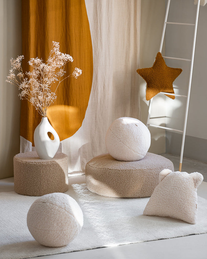 Een rustgevend interieur met zachte Wigiwama poefs, speelballen en het kussen met berenoortjes, in teddy stof. Ideaal voor een speelhoek vol comfort en stijl.