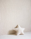 Stervormig sierkussen in cream teddystof van Wigiwama als decoratief accent tegen een zachte muur – perfect voor het ruimte-thema in de kinderkamer.