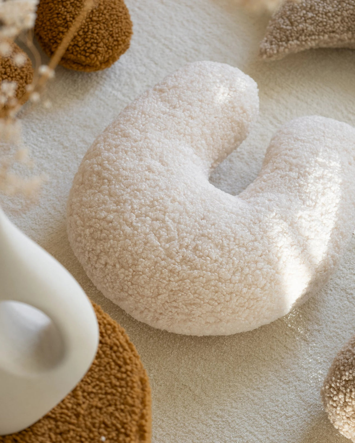 Close-up van het Wigiwama U-vorm kussen in de kleur cream – een zachte offwhite tint die licht en harmonie brengt in de kinderkamer of speelhoek. Comfortabel, duurzaam en veilig voor kinderen.