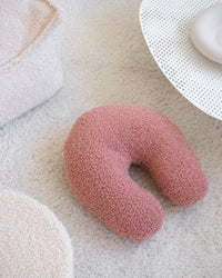 Het U-vormige kussen in guava pink – een serene zachtroze tint – ligt uitnodigend op een licht vloerkleed en voegt een speels én rustgevend accent toe aan de speelhoek, kinderkamer of woonkamer.