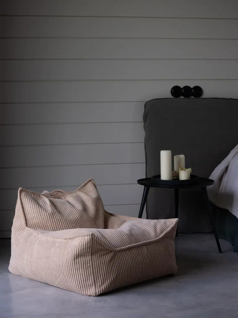 Gezellige lounge hoek met Brown Sugar zitzak, zwart houten bijzettafel en kaarsen voor sfeervolle momenten